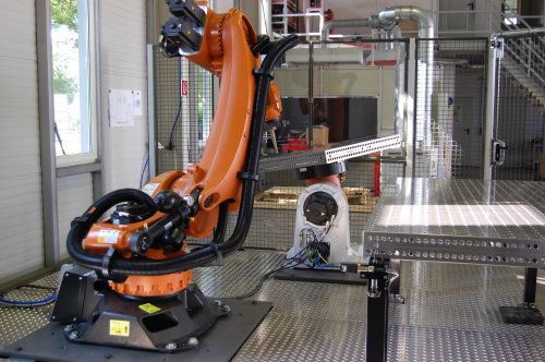 Foto Schwerlastroboter mit vier autarken Bearbeitungsstationen zum Prägen und Umbördeln